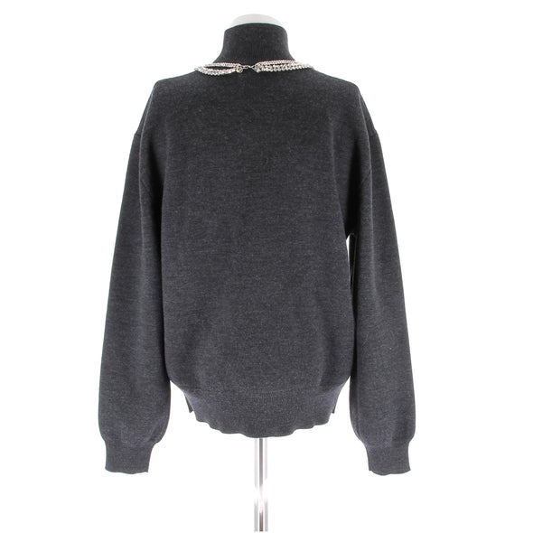 Pull gris en laine orné de bijoux